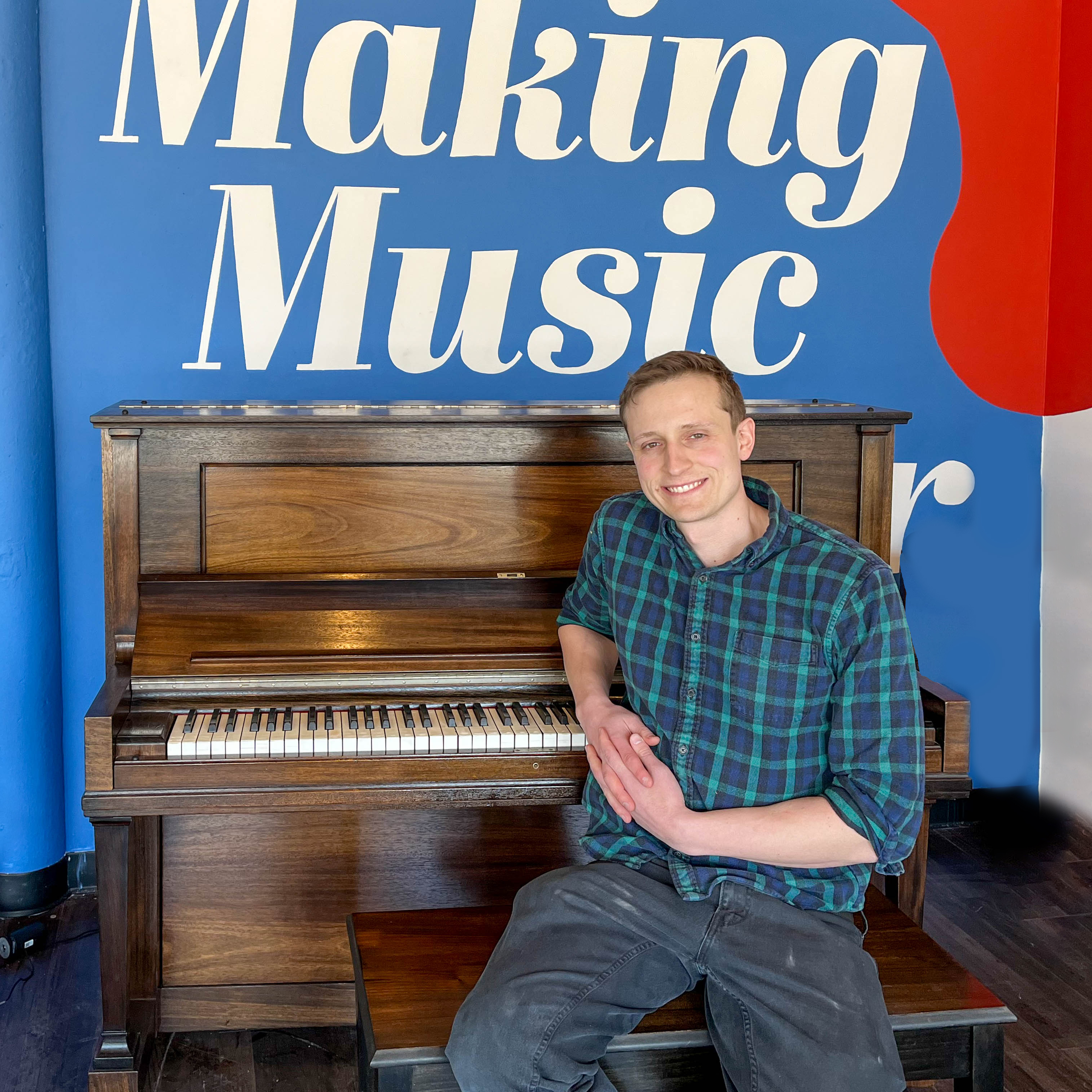 Brendan Alviani sitting in front of a piano