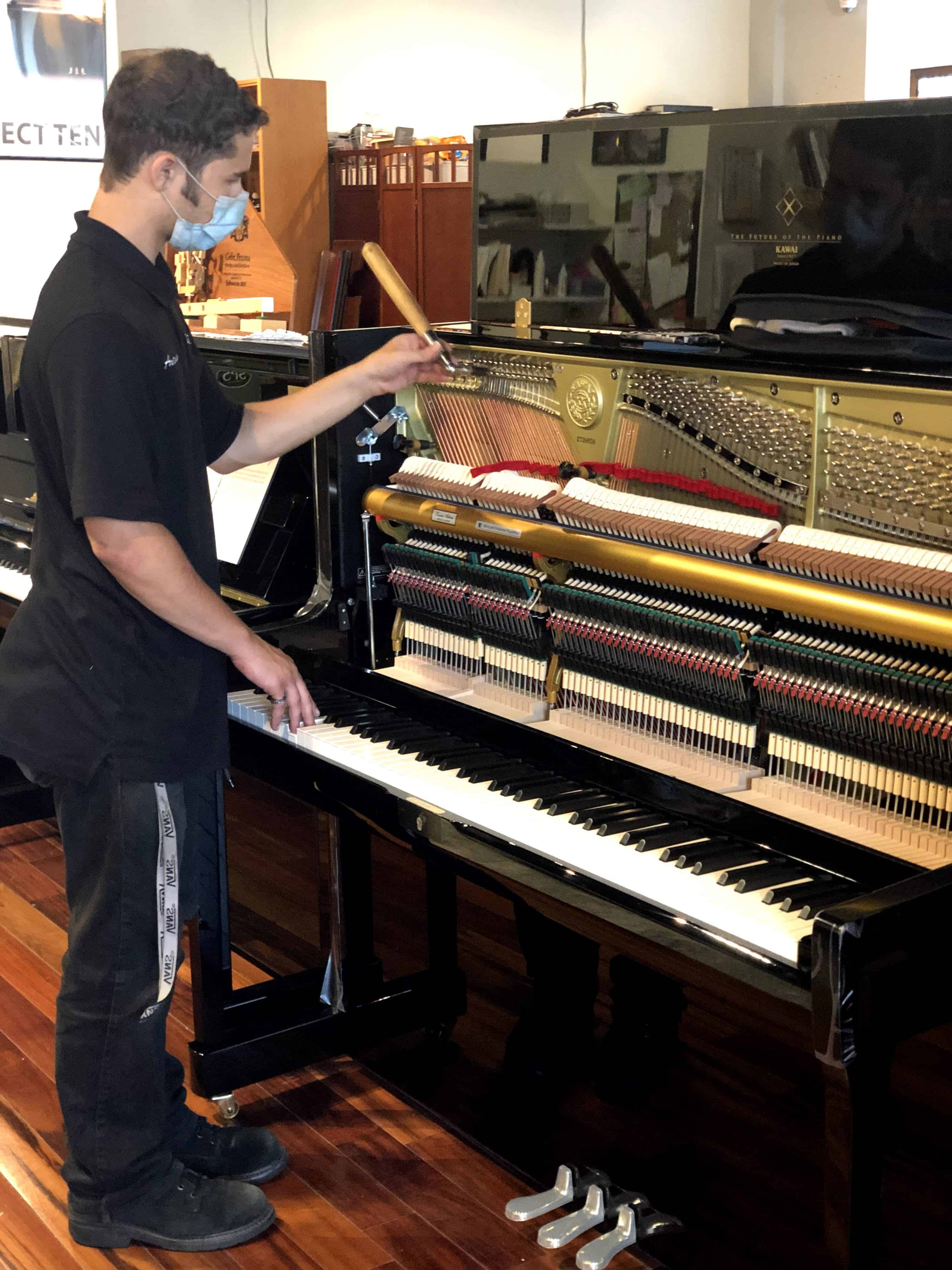 Antionio, a piano technician, tuning a Kawai piano.