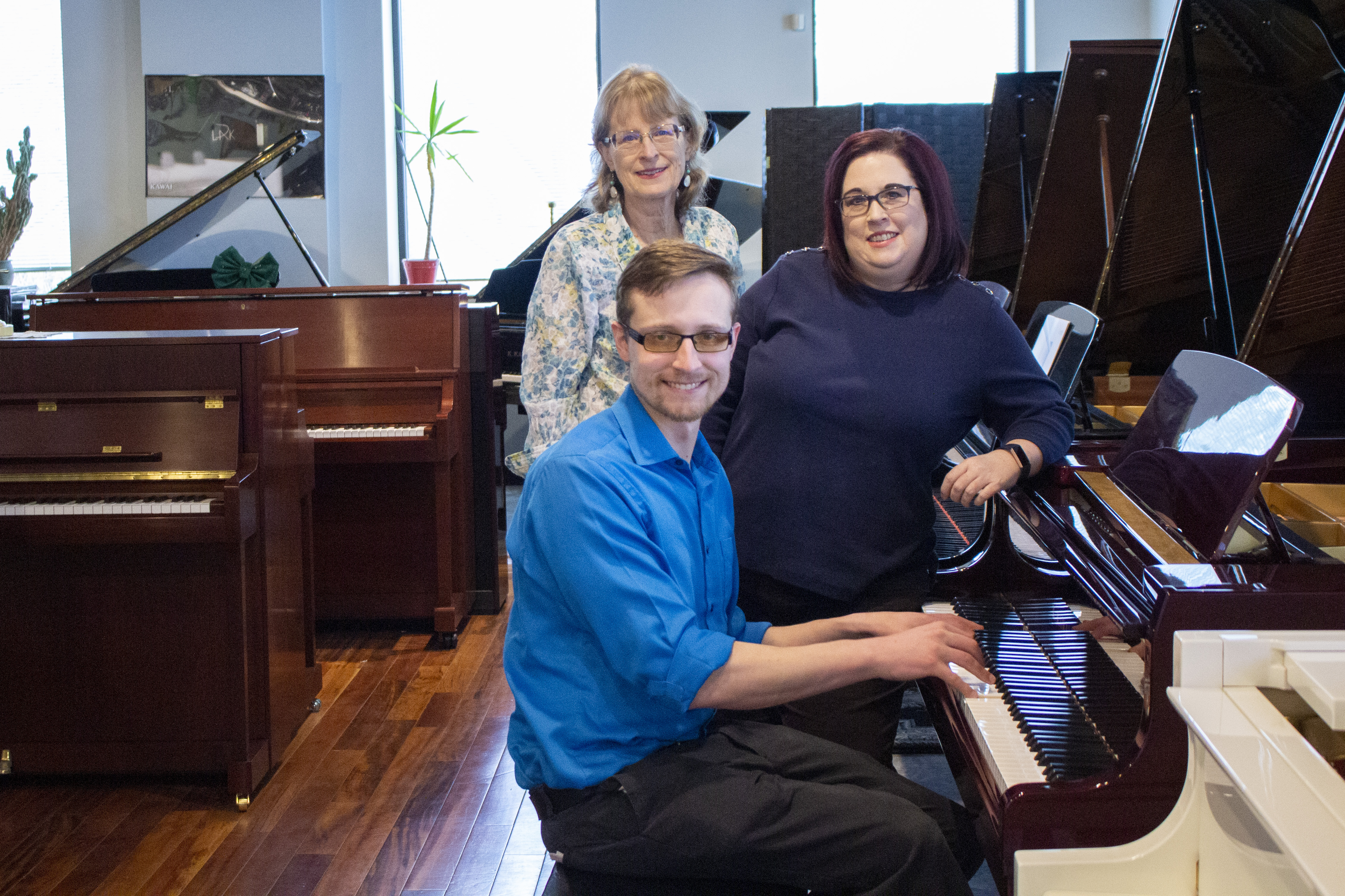 Family Piano Co management in front of piano showroom